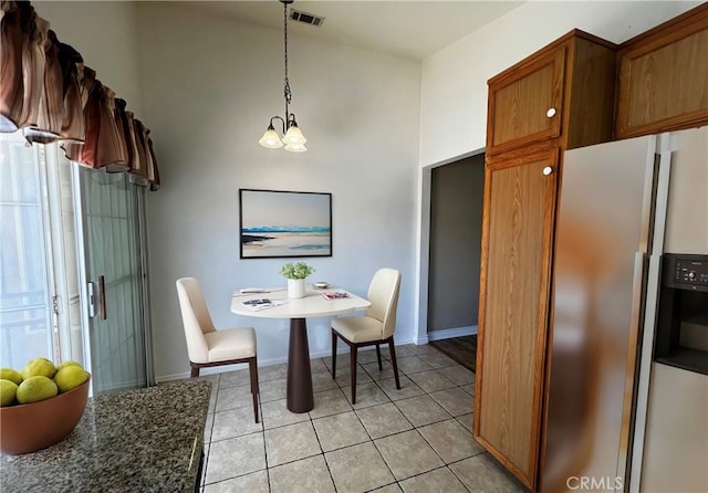 dining room featuring light tile patterned floors and an inviting chandelier