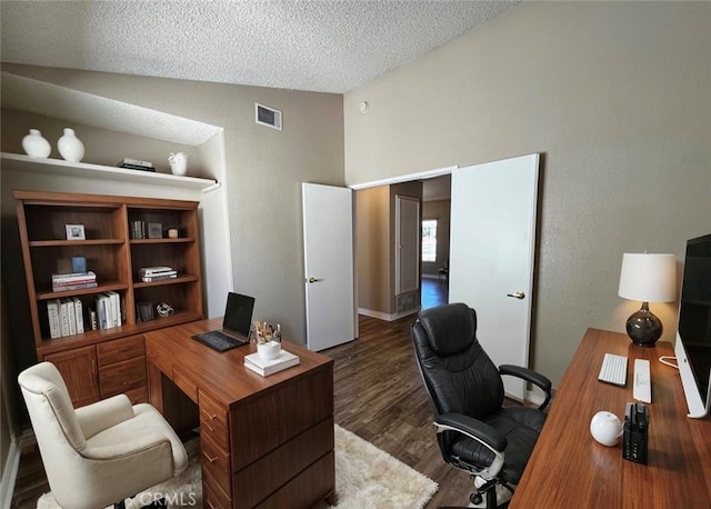 home office featuring a textured ceiling, dark hardwood / wood-style flooring, and lofted ceiling