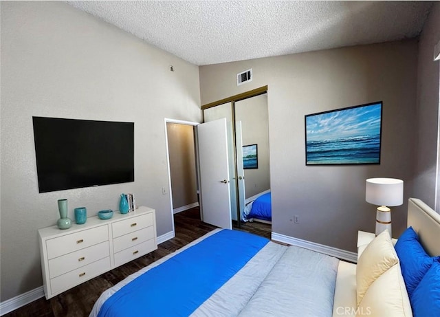 bedroom with dark hardwood / wood-style floors, a closet, a textured ceiling, and vaulted ceiling