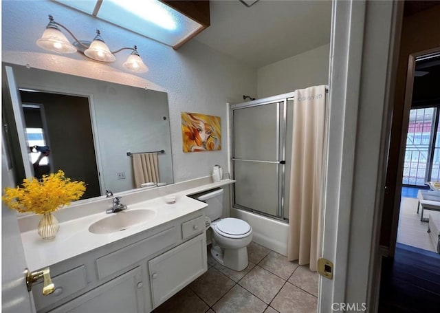 full bathroom with tile patterned floors, vanity, enclosed tub / shower combo, and toilet