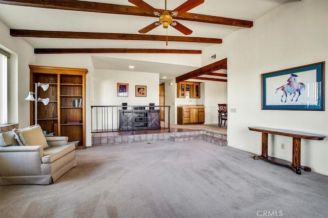 unfurnished living room featuring carpet, ceiling fan, and lofted ceiling with beams