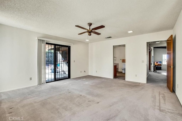 spare room with carpet flooring, a textured ceiling, and ceiling fan