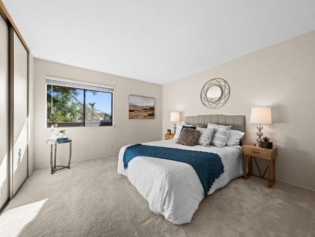 bedroom featuring light colored carpet and a closet