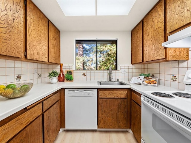 kitchen featuring sink, light hardwood / wood-style flooring, backsplash, white appliances, and exhaust hood