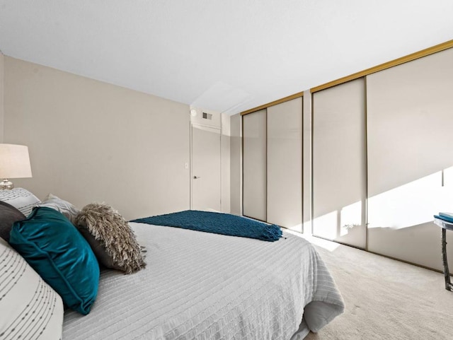 bedroom with light colored carpet and multiple closets