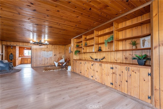 interior space featuring wood walls, light wood-type flooring, wood ceiling, and a wood stove