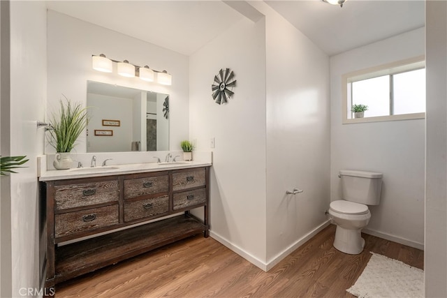 bathroom with toilet, vanity, and hardwood / wood-style flooring