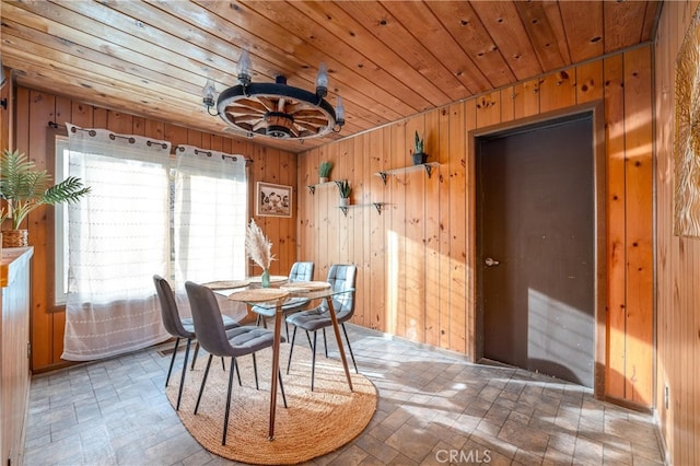 dining room with wooden ceiling and wooden walls