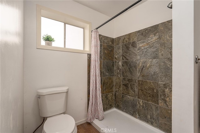 bathroom featuring hardwood / wood-style flooring, toilet, and a shower with shower curtain