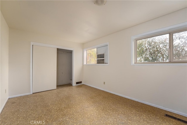 unfurnished bedroom featuring a closet and multiple windows