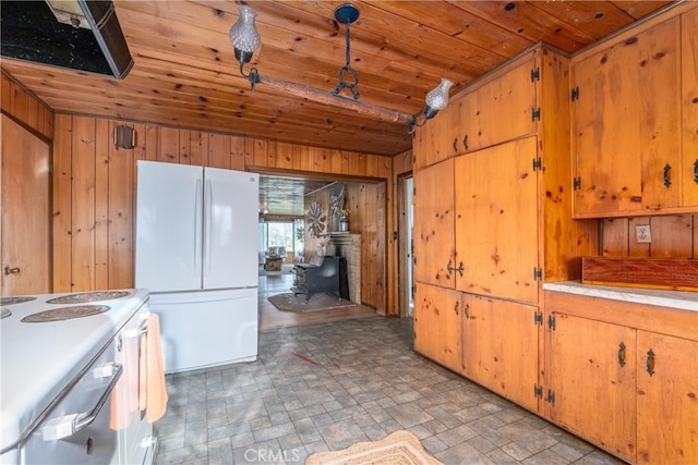 kitchen featuring white appliances, a wood stove, wooden ceiling, and wood walls