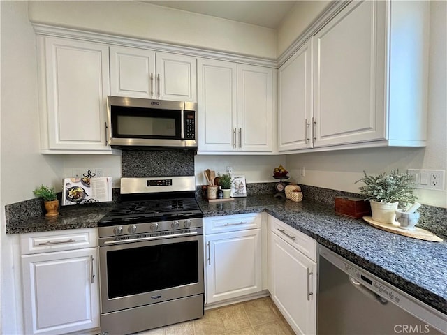 kitchen with white cabinets, appliances with stainless steel finishes, and light tile patterned flooring