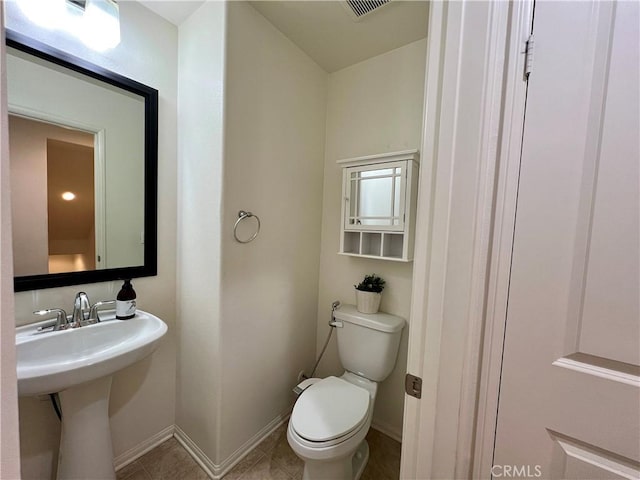 bathroom featuring toilet, sink, and tile patterned floors