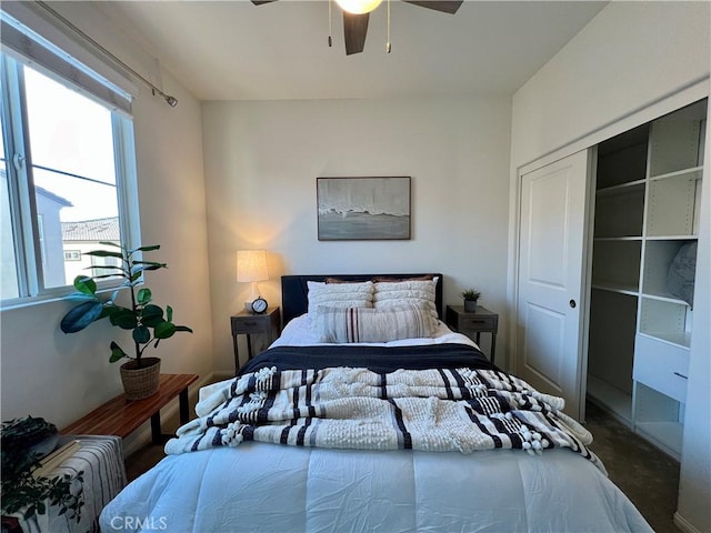 carpeted bedroom featuring ceiling fan and a closet