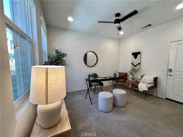 sitting room with ceiling fan and dark carpet