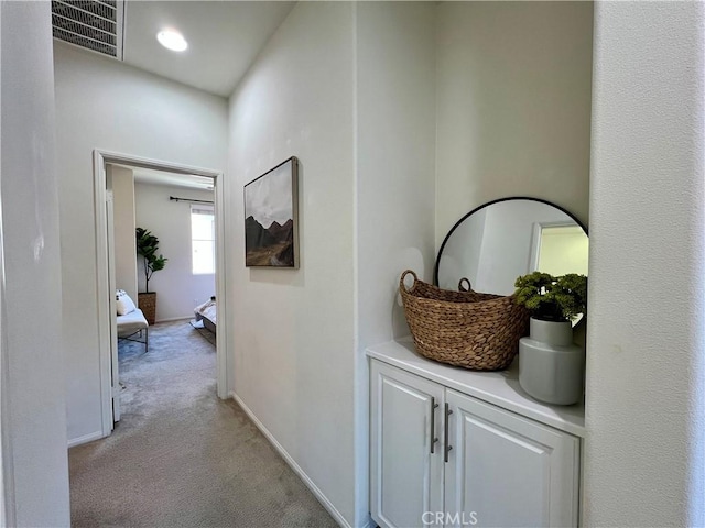 hall with light colored carpet