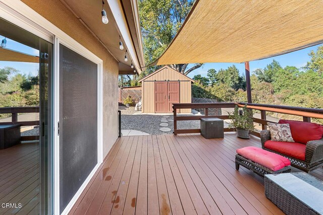 wooden terrace with a storage unit and an outdoor structure