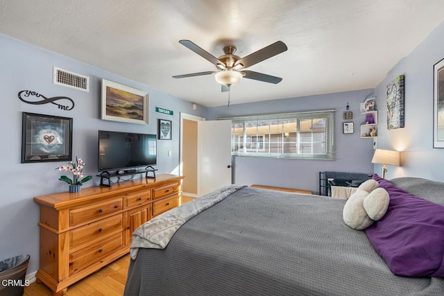 bedroom with ceiling fan, light wood-type flooring, and visible vents