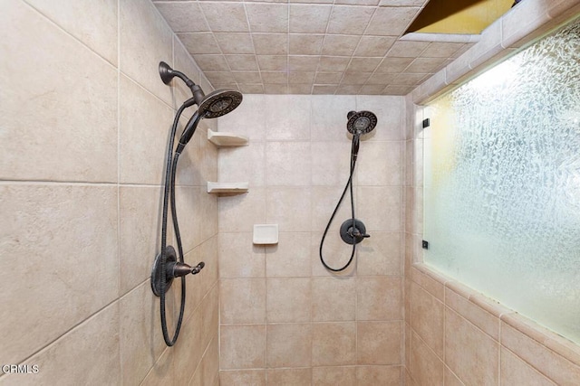 bathroom featuring a tile shower and a wealth of natural light