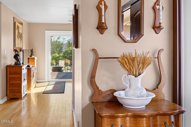 doorway to outside featuring wood finished floors and baseboards