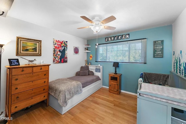 bedroom with light wood-style flooring, baseboards, and ceiling fan