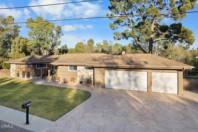 view of front of home with concrete driveway, stone siding, a chimney, an attached garage, and a front yard