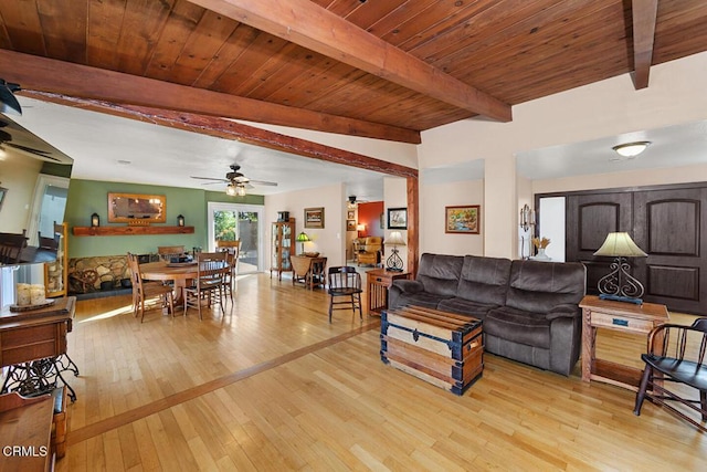 living room featuring light wood-style floors, wood ceiling, a ceiling fan, and beamed ceiling