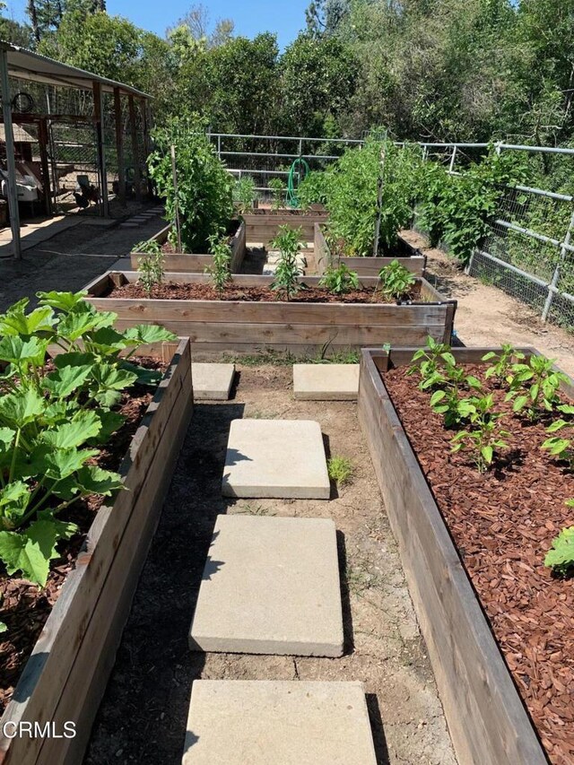 view of yard featuring fence and a vegetable garden