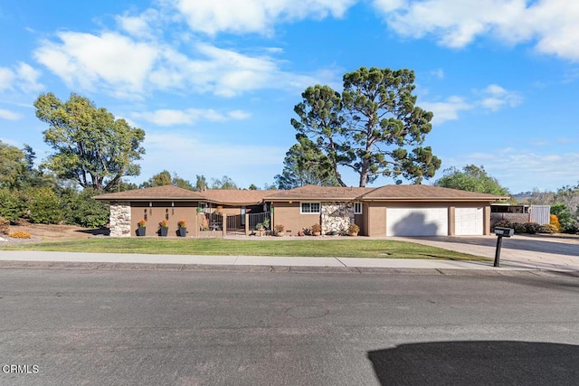 ranch-style home with an attached garage, driveway, a front lawn, and stucco siding