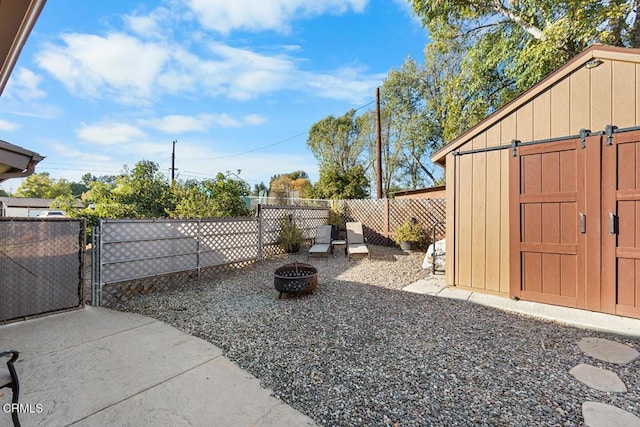 view of yard featuring fence private yard, a gate, a fire pit, and an outdoor structure