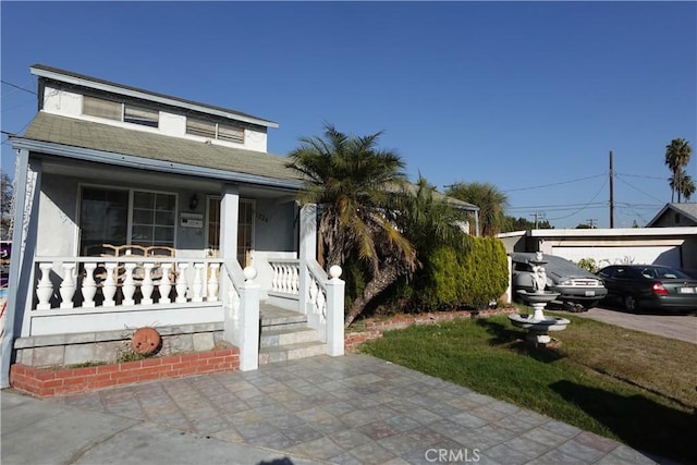 view of front of property with an outbuilding, a porch, and a garage