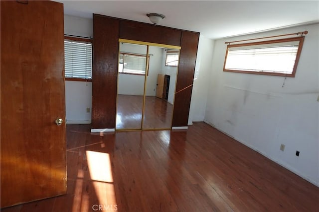 unfurnished bedroom with a closet and wood-type flooring