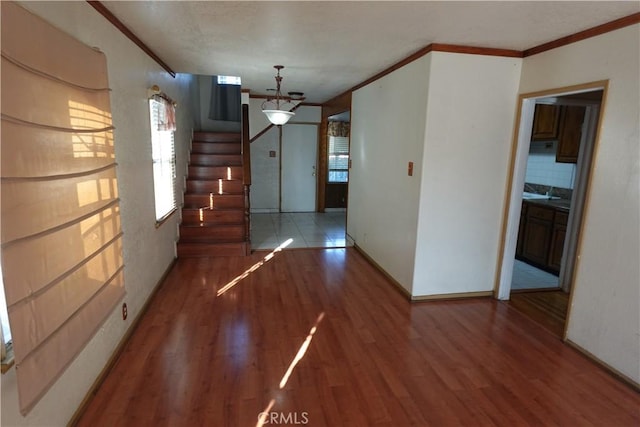 interior space with wood-type flooring, an inviting chandelier, and crown molding