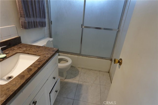 full bathroom with tile patterned floors, enclosed tub / shower combo, toilet, and vanity