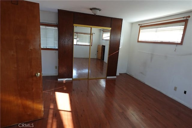 unfurnished bedroom with a closet and hardwood / wood-style flooring