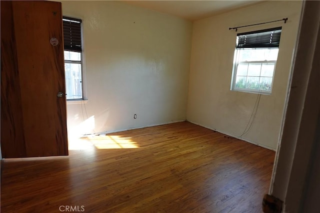 spare room featuring plenty of natural light and hardwood / wood-style floors