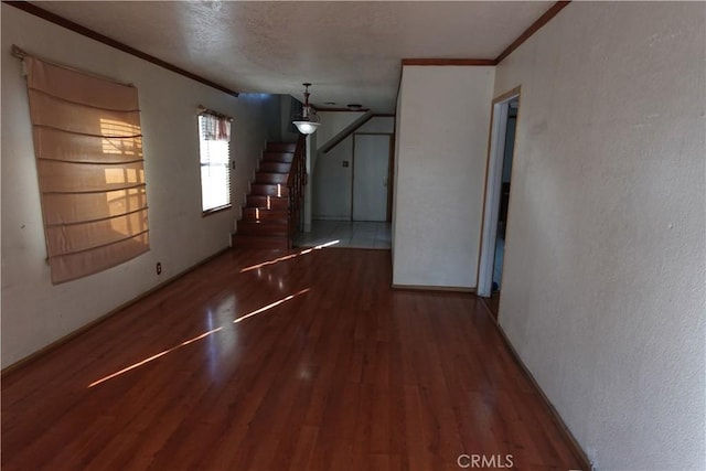 interior space with a textured ceiling, dark wood-type flooring, and ornamental molding