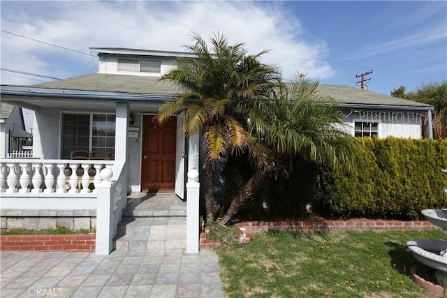 view of front of house with a front lawn and roof with shingles