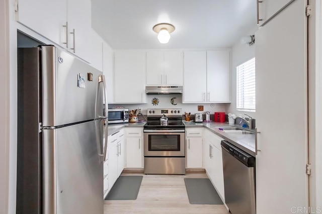 kitchen with white cabinetry, sink, light hardwood / wood-style floors, and appliances with stainless steel finishes