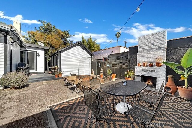 view of patio with an outdoor brick fireplace