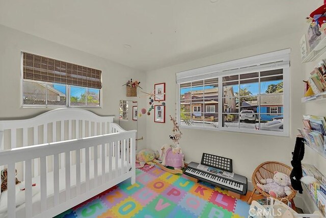 bedroom with a nursery area and multiple windows