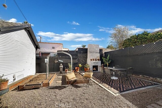 view of yard with a patio and exterior fireplace