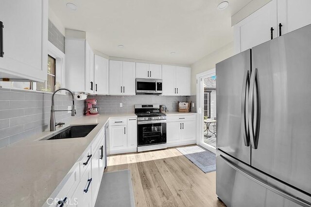 kitchen with plenty of natural light, sink, white cabinetry, and stainless steel appliances