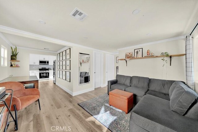 living room with ornamental molding and light wood-type flooring