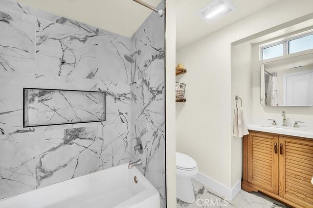 full bathroom with vanity, tiled shower / bath combo, and toilet