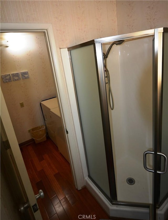 bathroom with hardwood / wood-style flooring and a shower with door