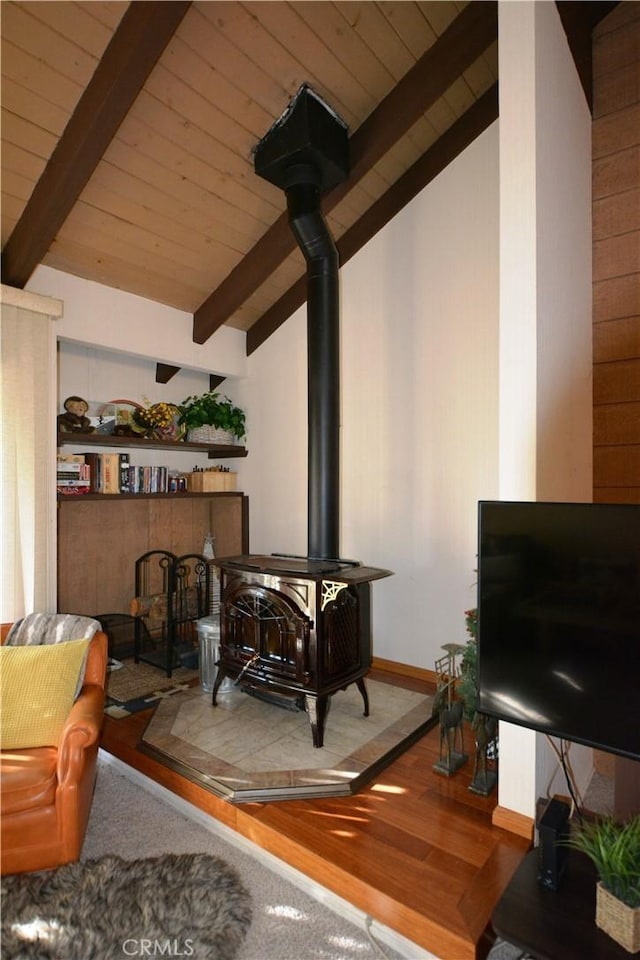 living room featuring a wood stove, hardwood / wood-style flooring, wood ceiling, and vaulted ceiling with beams