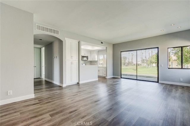 unfurnished living room with dark hardwood / wood-style flooring