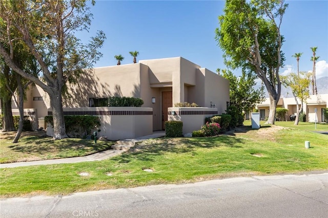 pueblo-style house with a front lawn