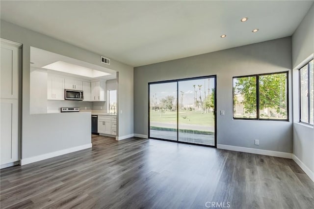 unfurnished living room with wood-type flooring and sink